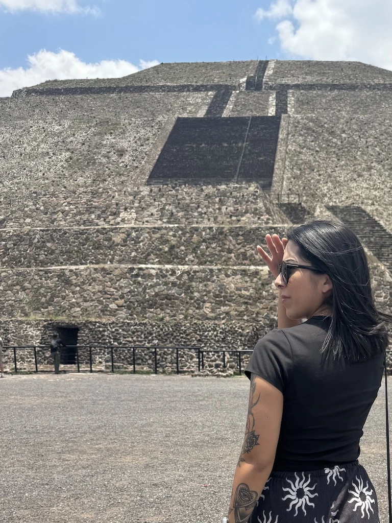 Woman standing in front of the Pyramid of the Sun at Teotihuacan, capturing a personal spiritual travel moment.